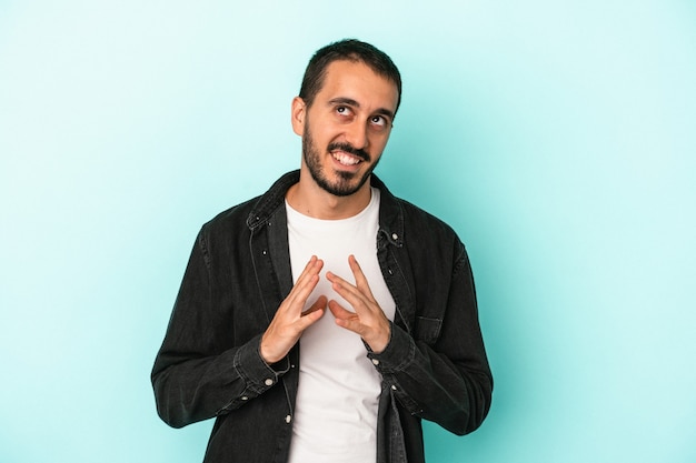 Jeune homme de race blanche isolé sur fond bleu, élaboration d'un plan à l'esprit, mise en place d'une idée.