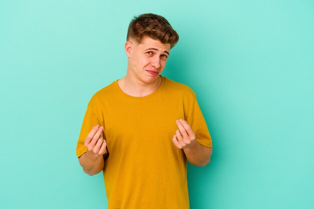 Jeune homme de race blanche isolé sur fond bleu montrant qu'elle n'a pas d'argent.