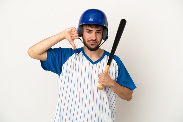 Jeune homme de race blanche jouant au baseball isolé sur fond blanc montrant le pouce vers le bas avec une expression négative