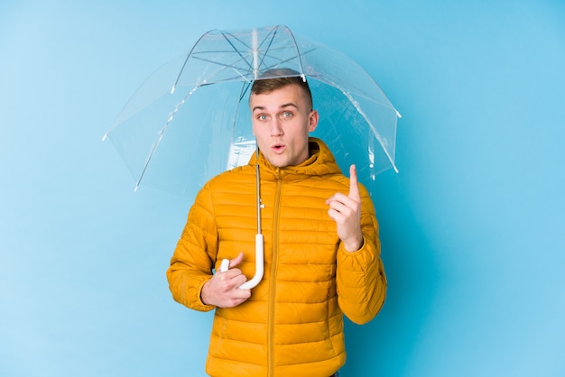 Jeune homme de race blanche avec un parapluie ayant une excellente idée, concept de créativité.