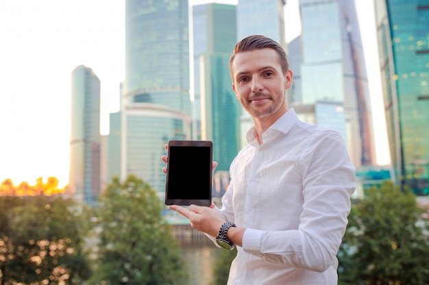 Jeune homme de race blanche tenant le smartphone pour le travail de l'entreprise.