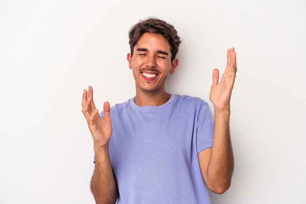 Jeune homme de race mixte isolé sur fond blanc joyeux rire beaucoup. Notion de bonheur.