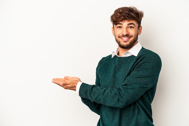 Jeune homme de race mixte isolé sur fond gris tenant un espace de copie sur une paume.