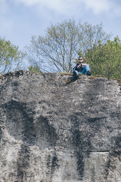 Jeune homme randonneur au sommet de la falaise