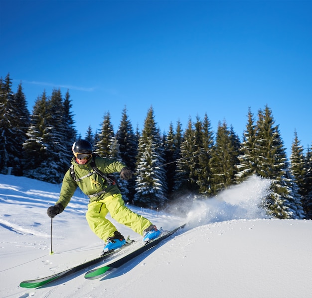 Jeune homme randonneur skiant des pentes montantes et descendantes. Skieur masculin s'entraînant en journée d'hiver ensoleillée. Concept de ski de randonnée.