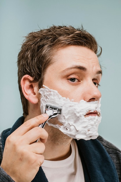 Jeune homme rasant sa barbe