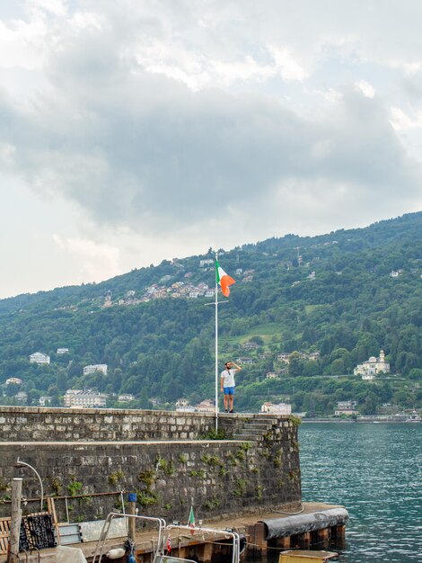 un jeune homme à la recherche d'un drapeau italien dans un port italien