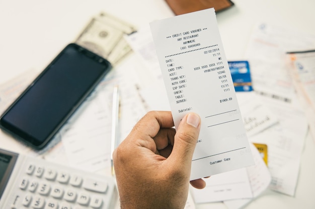 Le jeune homme regardait la facture pour calculer ses revenus et dépenses