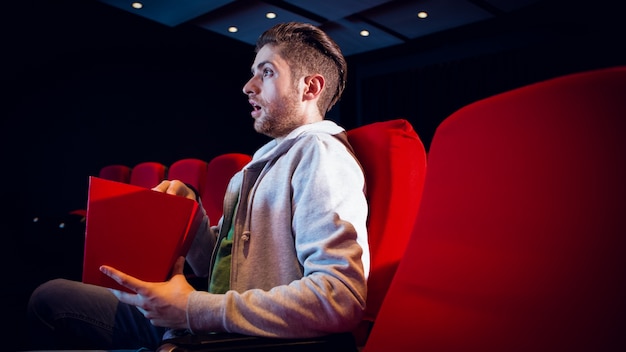 Jeune homme regardant un film