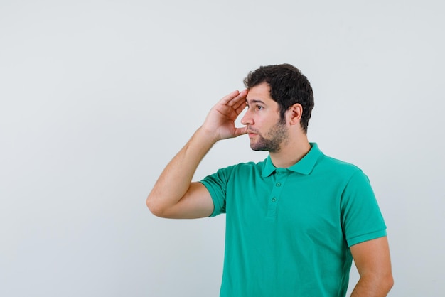 Jeune homme regardant loin sur la gauche sur fond blanc