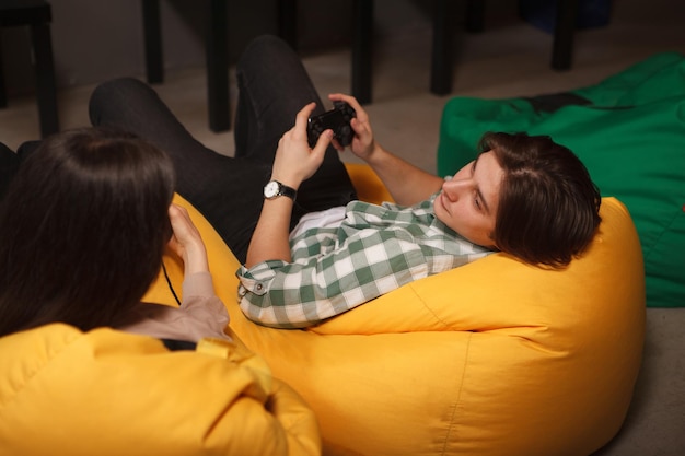 Photo jeune homme regardant sa petite amie tout en jouant à des jeux vidéo ensemble
