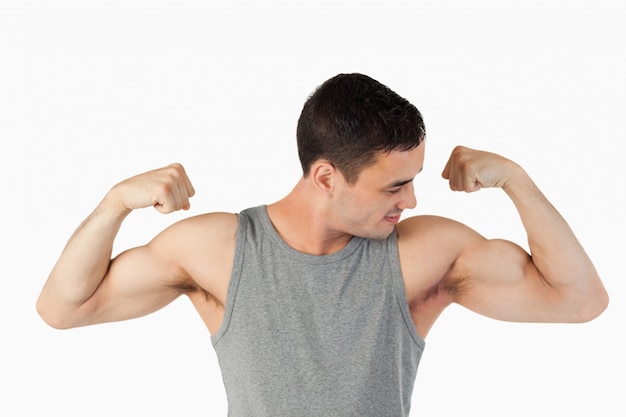 Jeune homme regardant ses muscles