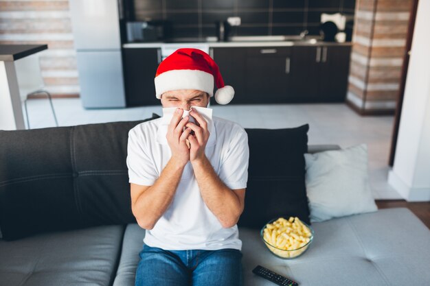 Jeune homme regardant la télévision dans son propre appartement