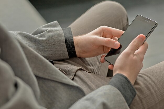 Jeune homme regarde l'écran du téléphone.