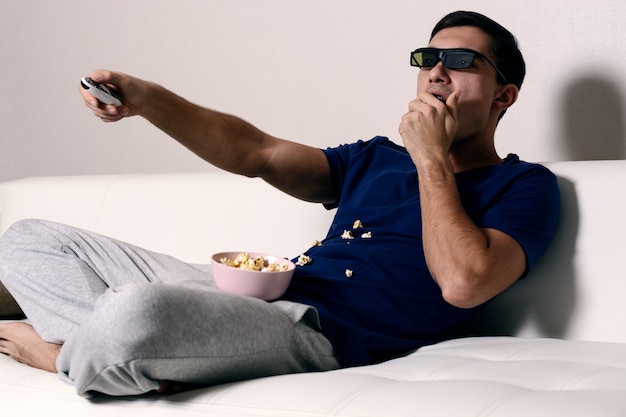 Jeune homme, regarder film, dans, lunettes 3d, et, manger, pop-corn