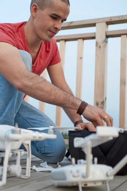 Jeune homme réglage drone dans le parc.