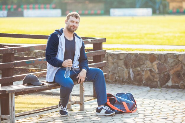 Le jeune homme règle sa musique préférée sur son smartphone avant de s'entraîner