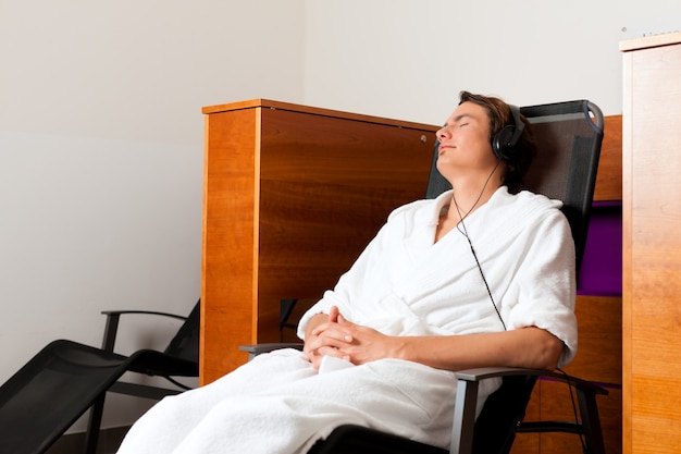 Jeune Homme Relaxant Au Spa Avec Musique