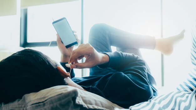 Jeune homme relaxant à l'écoute de la musique du téléphone mobile.