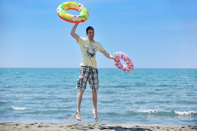 jeune homme relaxant sur la plage au coucher du soleil