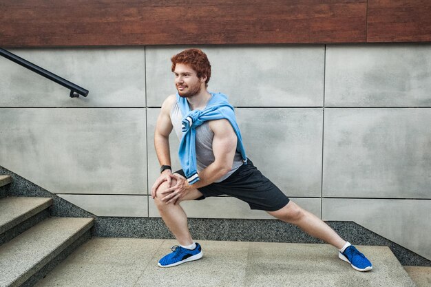 Jeune homme de remise en forme en vêtements de sport faisant du yoga