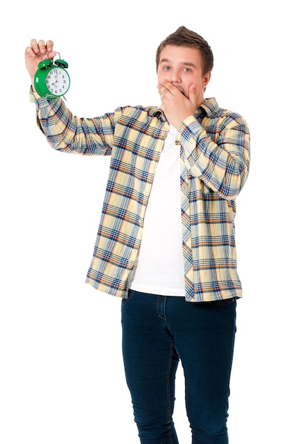 Jeune homme avec un réveil isolé sur fond blanc