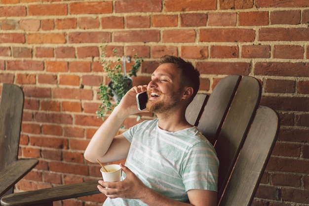 Le jeune homme rit et parle au téléphone