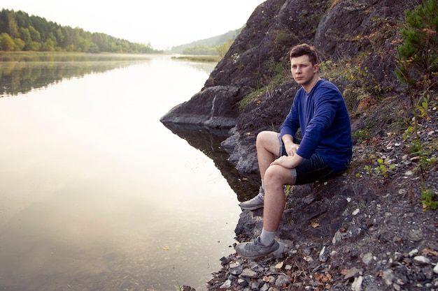 jeune homme rivière rive nature mode de vie actif randonnée loisirs de plein air actif aventure seul surface sac à dos caucasien environnement forêt vert randonnée sain randonnée randonneur hikin