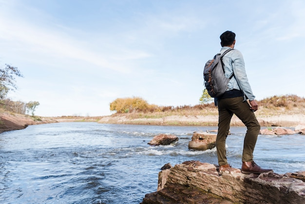 Jeune homme sur les rochers près du lac