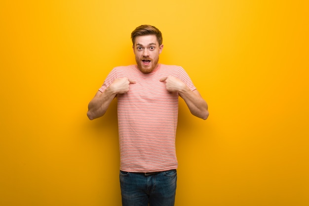 Jeune homme rousse surpris, qui a du succès et de la prospérité