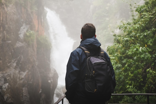 Jeune homme routard debout devant la cascade du Pont d'Espagne Cauterets