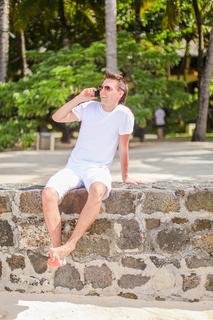 Photo jeune homme s'amusant sur le bord de mer tropical.