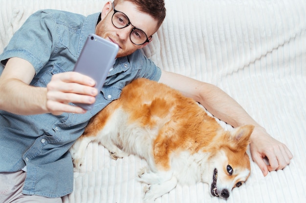 Jeune homme s'amusant avec son chien sur le lit