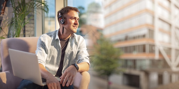 Jeune homme s'asseoir et parler avec les mains libres et sourire