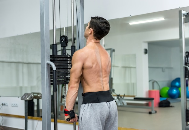 Jeune homme s'entraînant à l'équipement sportif en salle de sport