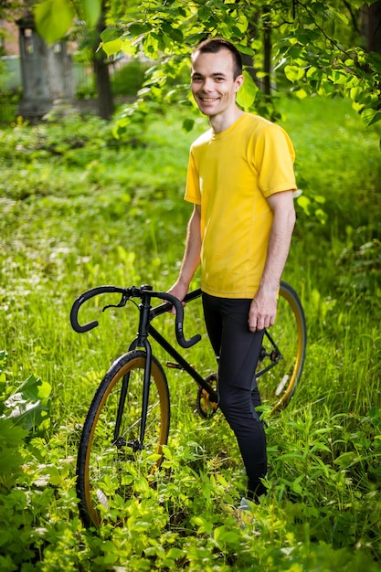 Un jeune homme s'est arrêté pour se reposer avec son vélo dans un parc public