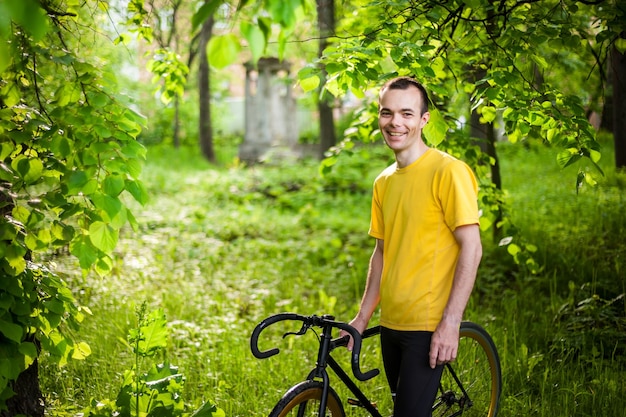 Un jeune homme s'est arrêté pour se reposer avec son vélo dans un parc public