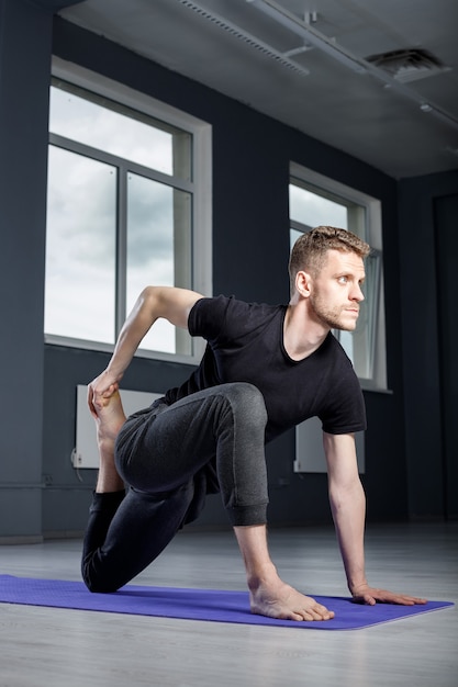 Jeune homme s'étend dans la salle de gym