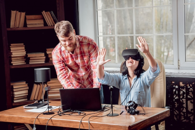 Le jeune homme avec sa petite amie joue à un jeu au bureau.