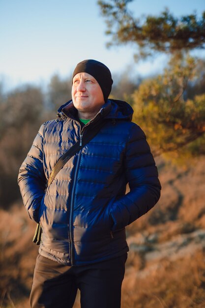 Jeune homme avec sac à dos debout sur la haute montagne et se préparant à filmer des vidéos et des photos avec un équipement professionnel Concept vacances et voyage