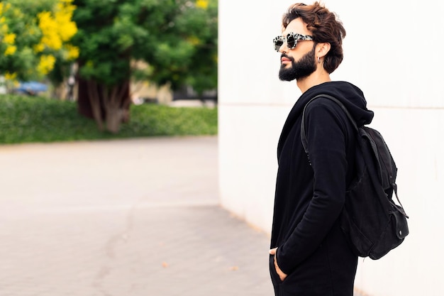 Jeune homme avec sac à dos et lunettes de soleil à la mode