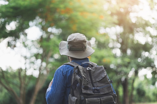 Un jeune homme avec un sac à dos marche seul sur la route. L'homme attend avec impatience un voyage intéressant.