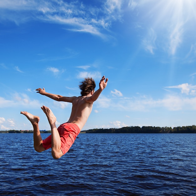 Jeune homme sautant dans l'eau