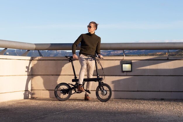 Jeune homme se déplaçant avec un vélo électrique pour être éco-durable et éviter la pollution des transports et les foules