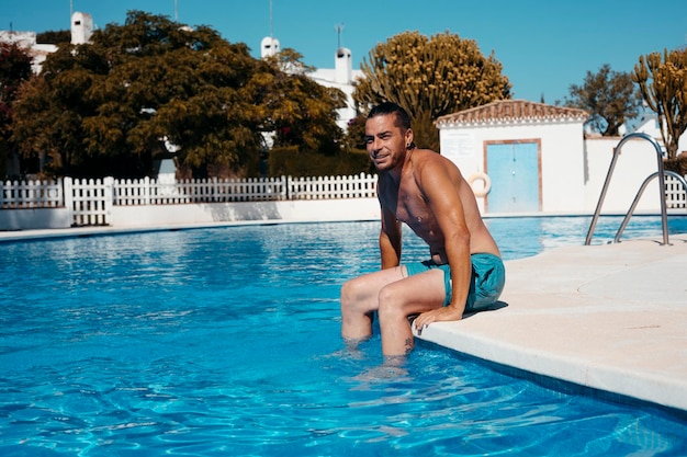 Jeune homme se détendre dans la piscine Photo de haute qualité