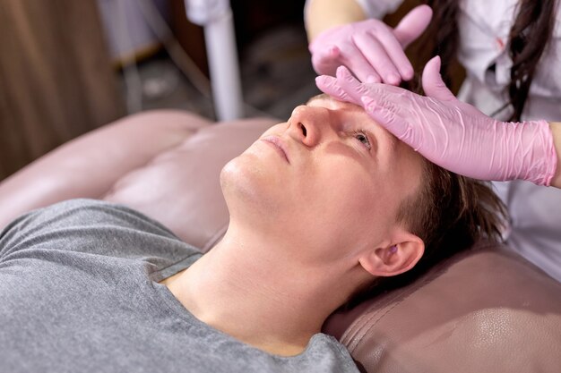 Jeune homme se détendre sur une table de massage recevant un massage, bénéficiant d'un massage sur un traitement spa.