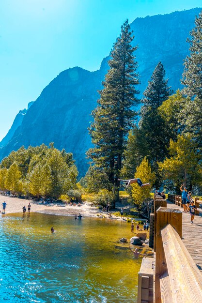 Un jeune homme se jetant dans l'eau à Swinging Bridge Yosemite valley