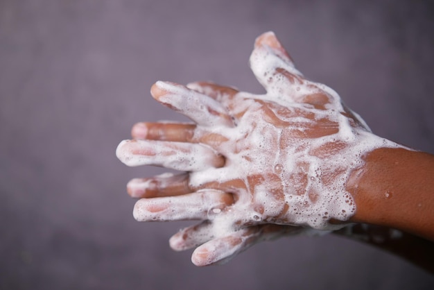 Jeune homme se laver les mains avec de l'eau chaude savonneuse