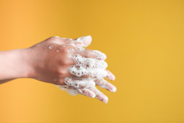 Jeune homme se laver les mains avec de l'eau chaude savonneuse