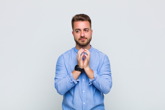 Jeune homme se sentant fier, espiègle et arrogant tout en élaborant un plan diabolique ou en pensant à un truc